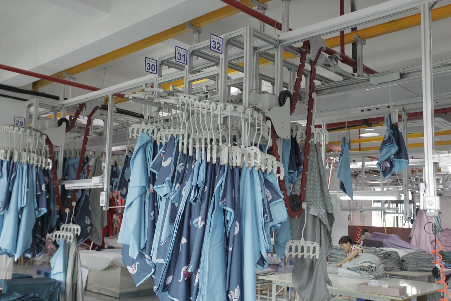 Overhead storage buffer rails above a hanger system production line